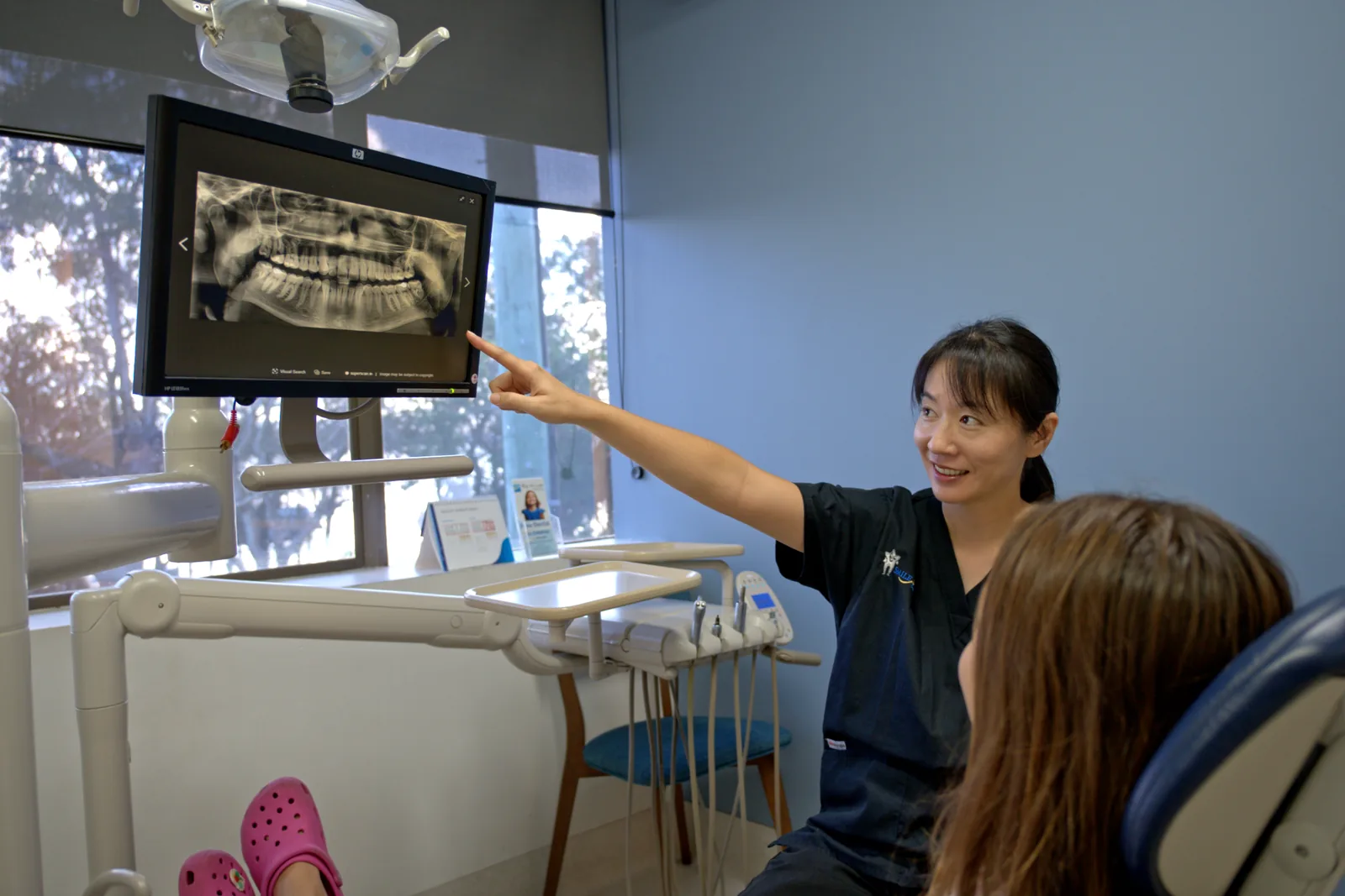 Dr Melody Healy reviewing a dental X-ray with a patient at Smile Star Dental, Warners Bay.